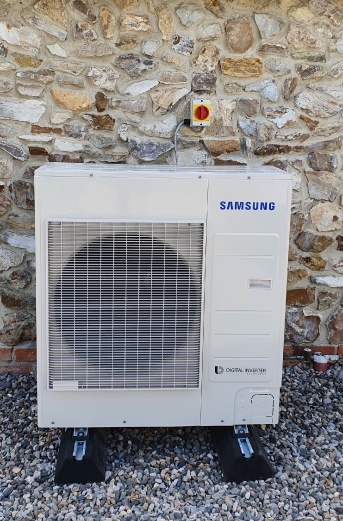 hybrid air source heat pump installed at a house next to an exterior wall