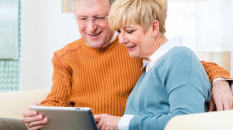 Couple looking on tablet for boiler cover deals