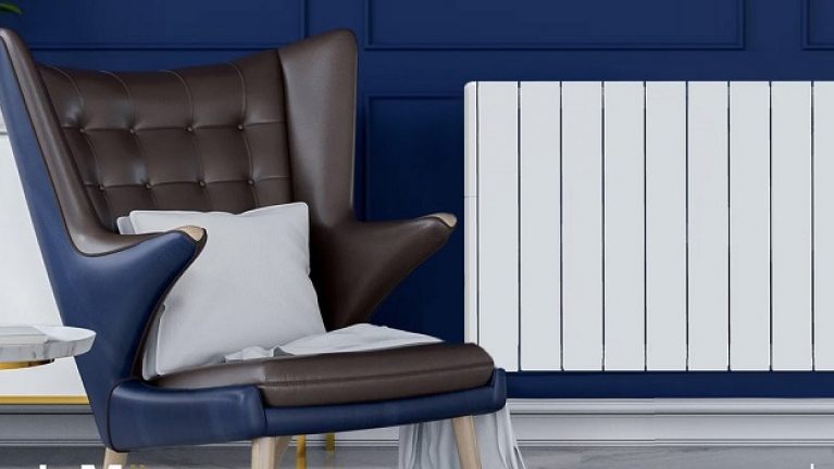 Electric radiator on wall next to a chair